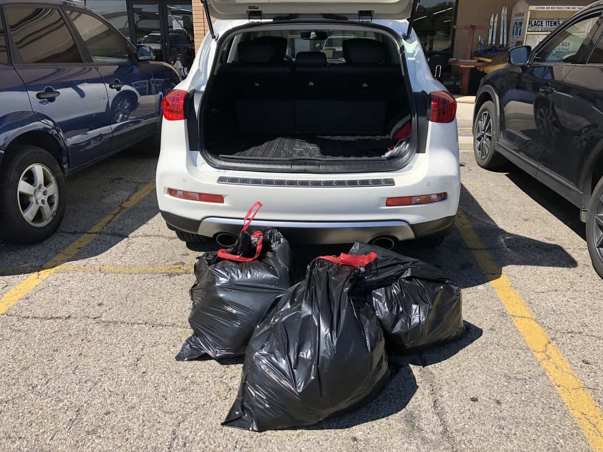 car with bags of discarded clothing
